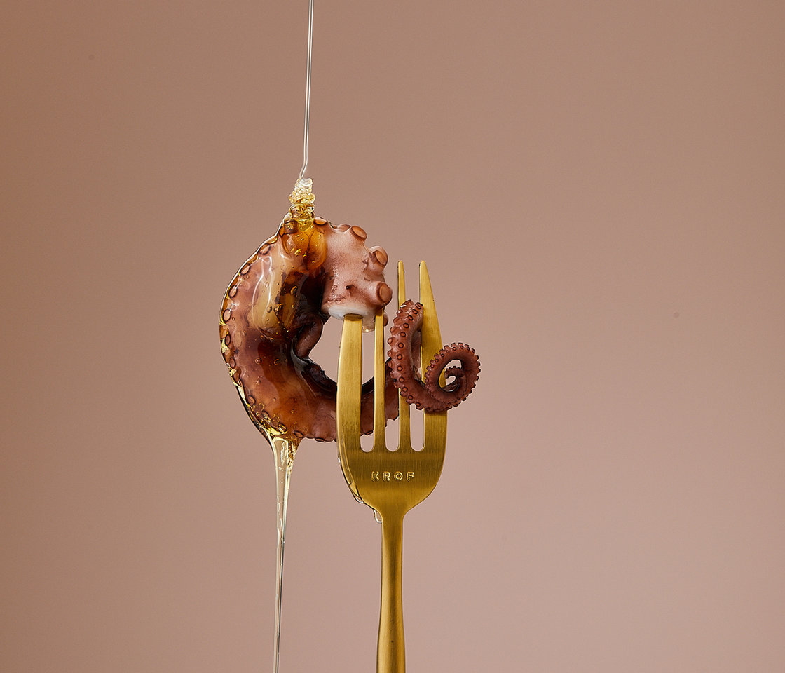 A gold KROF fork holding octopus